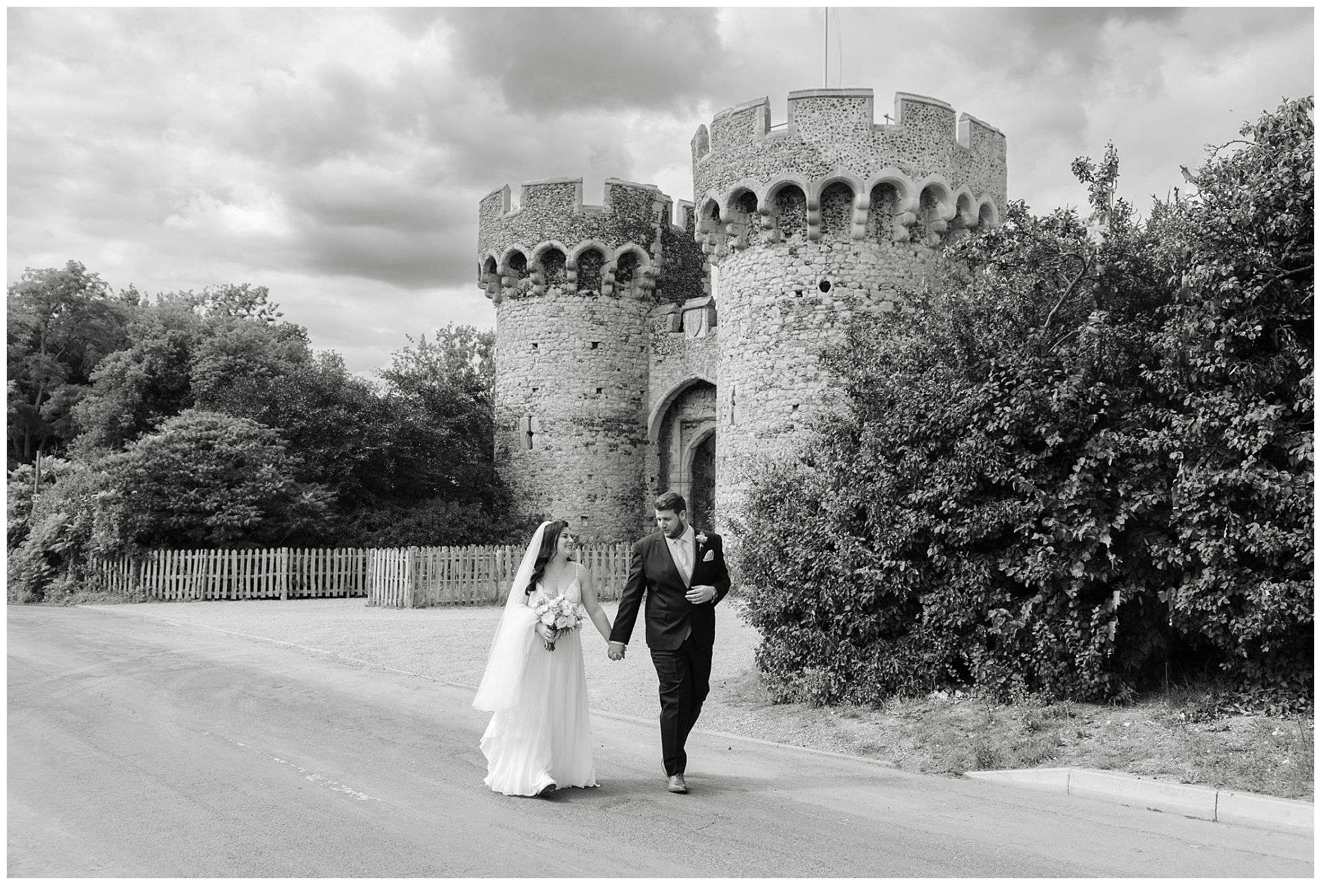 bride and groom photographs walking in lane holding hands at Cooling Castle Barn Wedding Venue by Louisa Dettmer Photography
