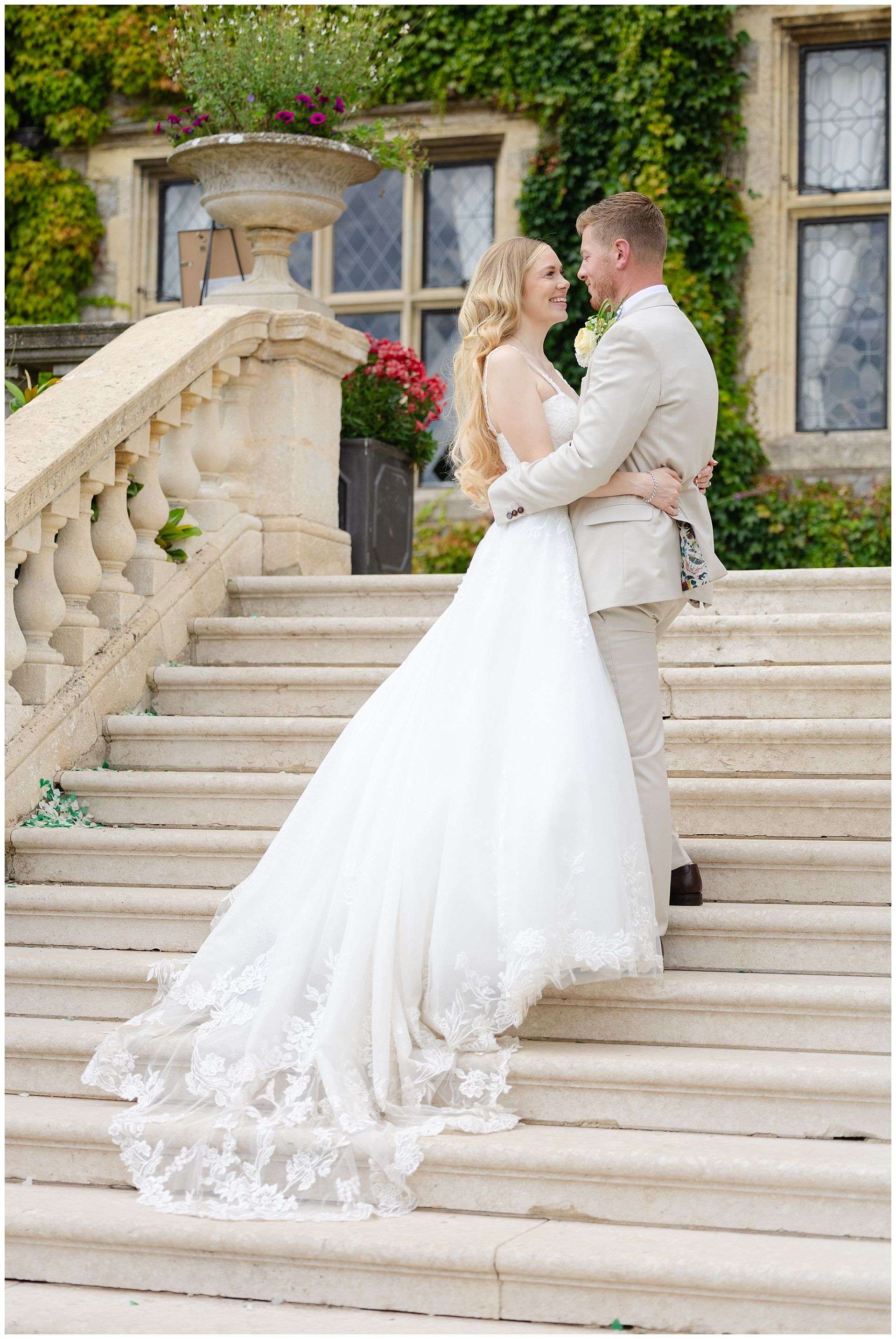 bride and groom on the steps at Eastwell Manor by Louisa Dettmer Photography