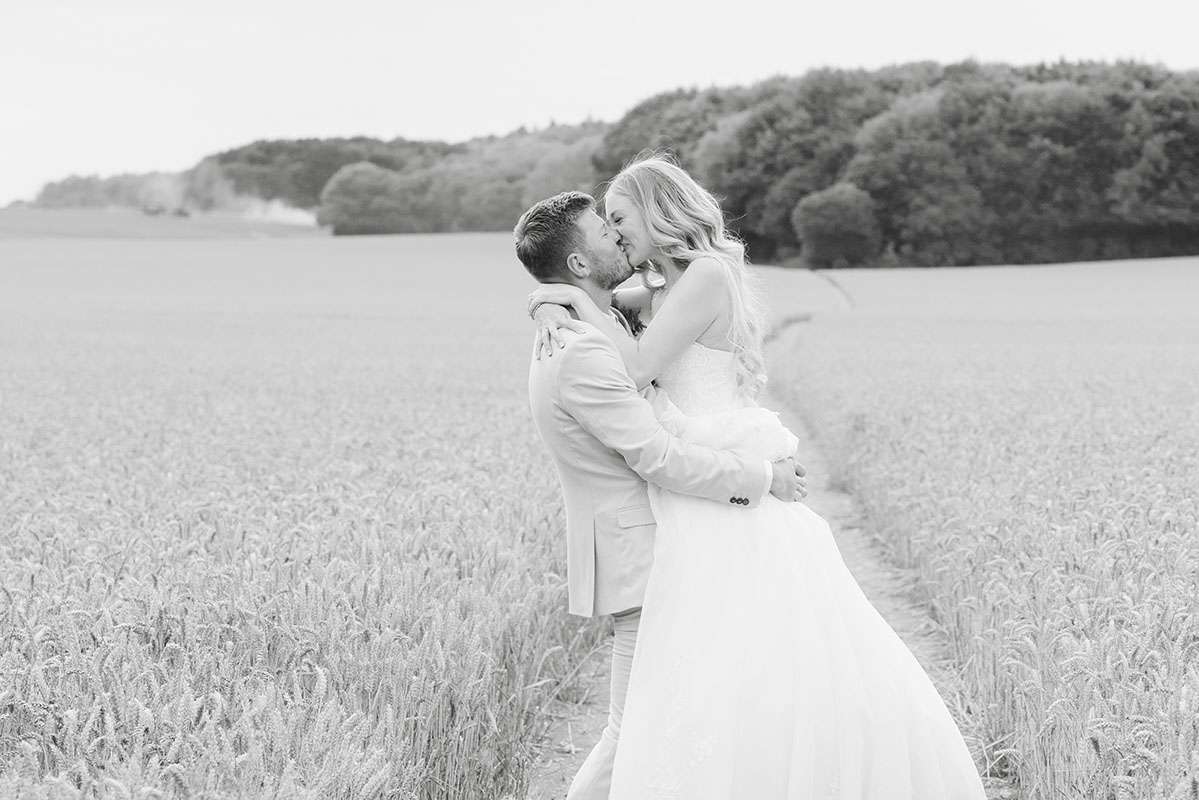 bride and groom in corn field at Eastwell Manor by Louisa Dettmer Photography