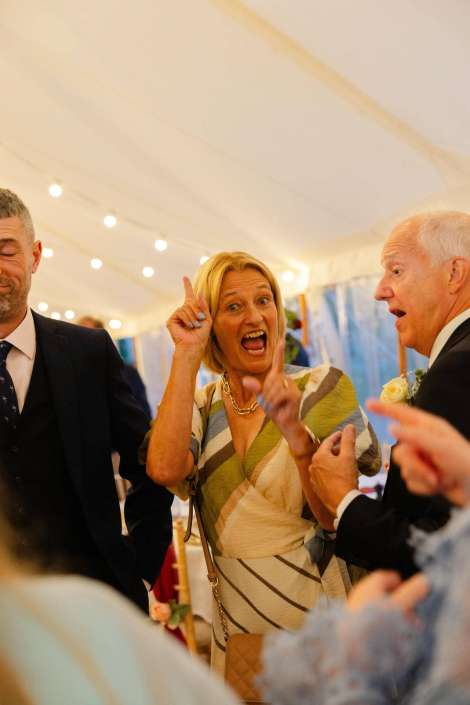 lively woman at a wedding reception Woman animatedly speaking with guests.