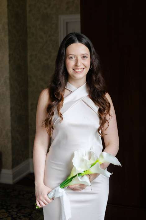 bride with calla lilies Smiling woman in a white dress holding a bouquet of white calla lilies.