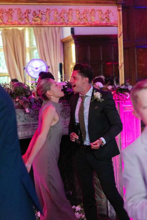 couple kissing at wedding reception Happy couple laughing and singing together at an elegant indoor wedding reception party.